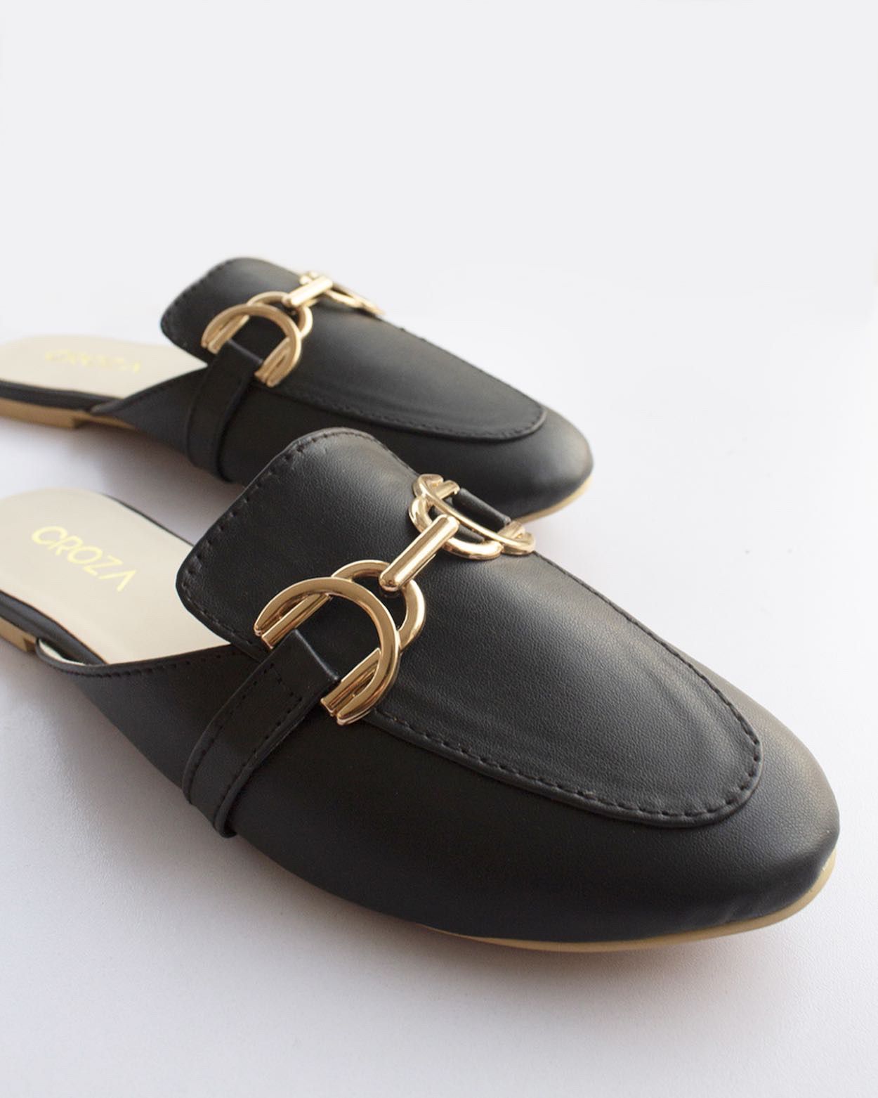 Black mules with golden accessory